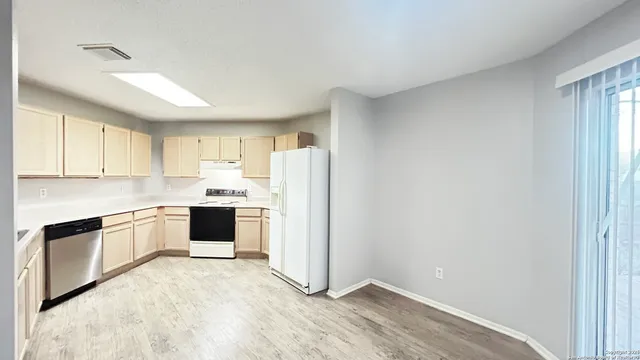 a kitchen with a refrigerator sink and cabinets