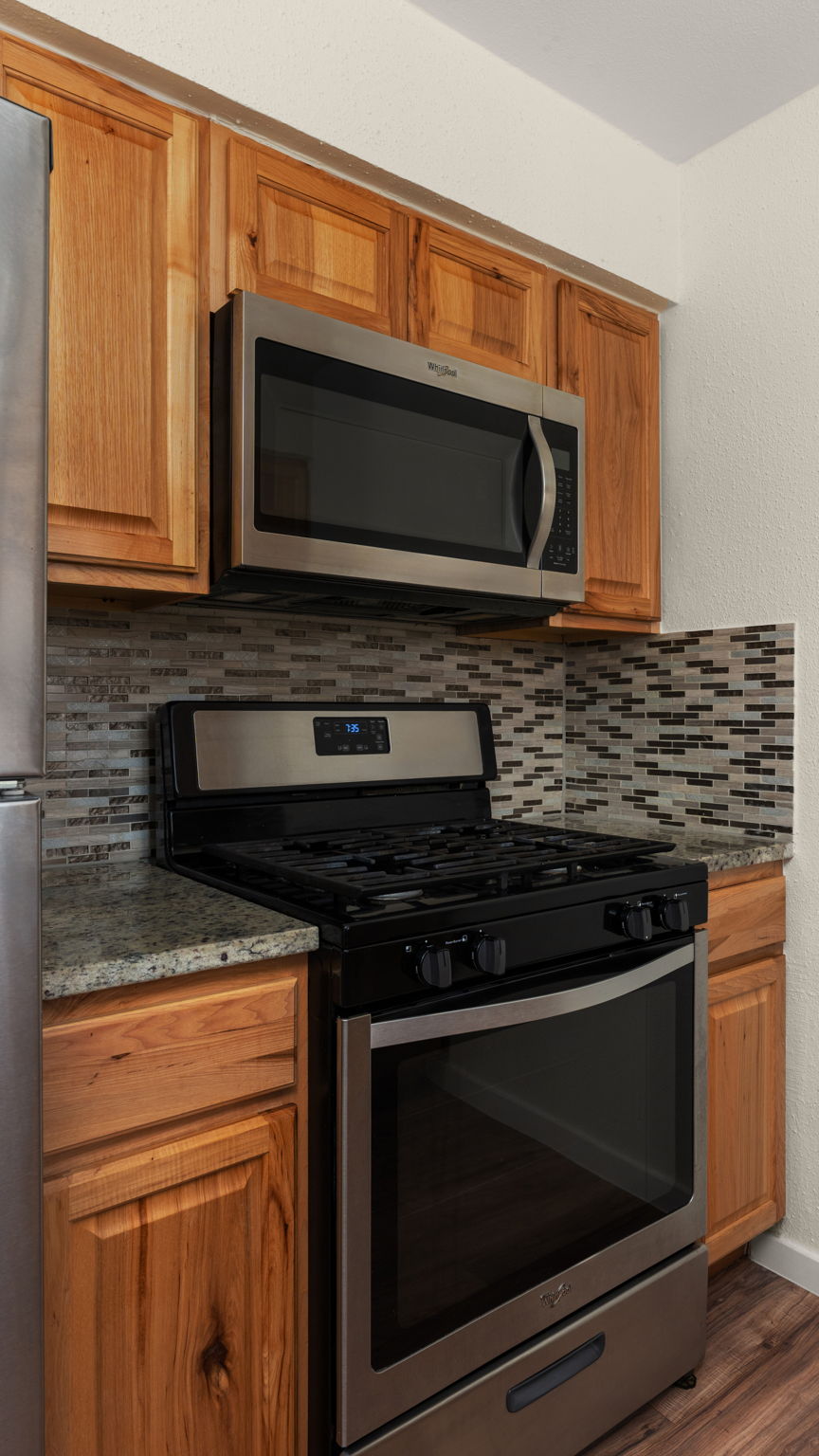 1618 Chippeway Lane Austin, TX 78745 - Photo 13 of 39 Kitchen with stainless steel gas appliances, wood finish cabinetry. vinyl plank flooring