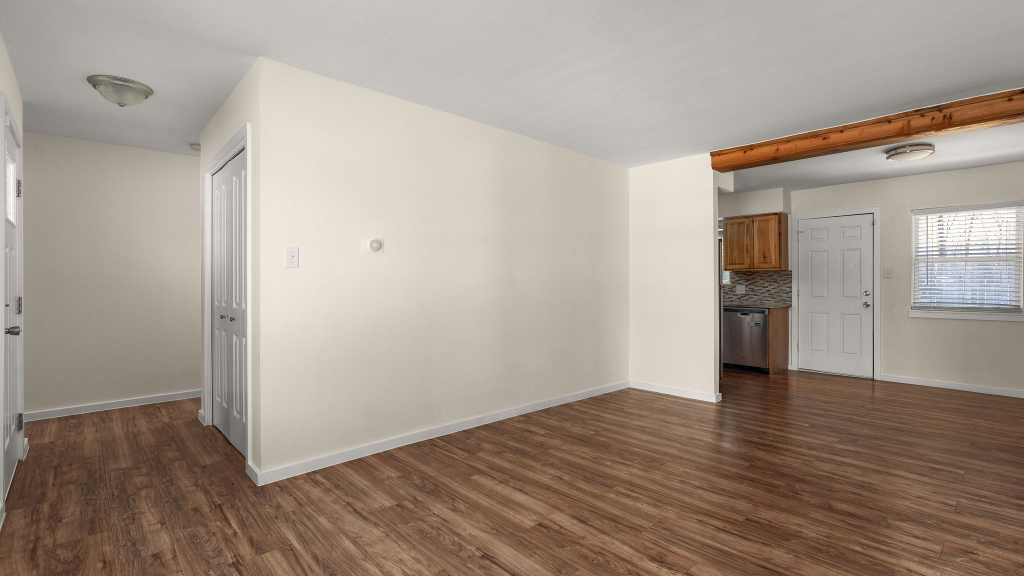 1618 Chippeway Lane Austin, TX 78745 - Photo 16 of 39 Unfurnished living room with wood-style flooring and baseboards. Fresh Simply White, Benjamin moore paint