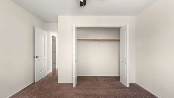 a view of walk in closet with empty racks