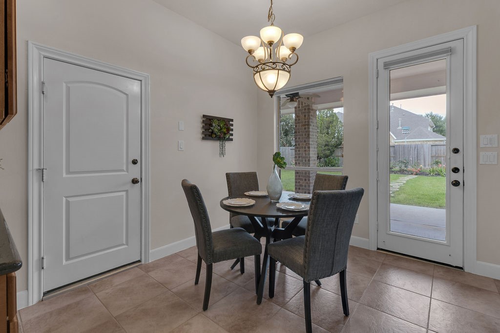 7306 Starflower Katy, TX 77494 - Photo 17 of 50 a view of a dining room with furniture a chandelier and wooden floor