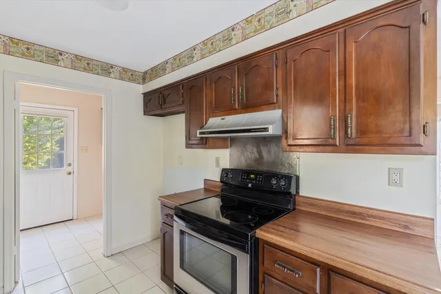 a kitchen with stainless steel appliances wooden cabinets and a stove top oven