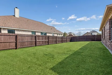 a view of backyard with seating area and small garden