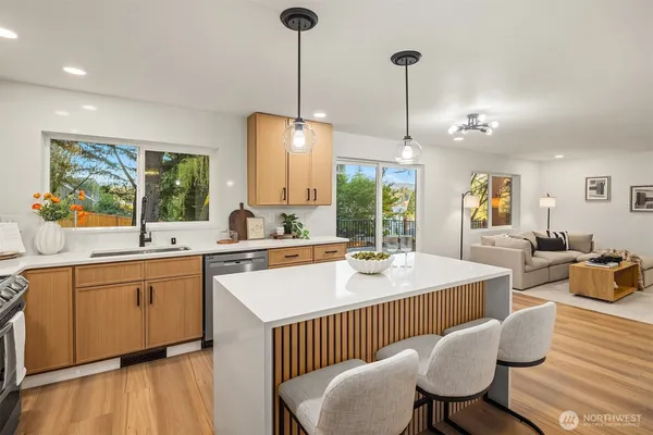 a large kitchen with sink a center island and living room view