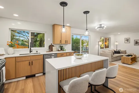 a large kitchen with sink a center island and living room view