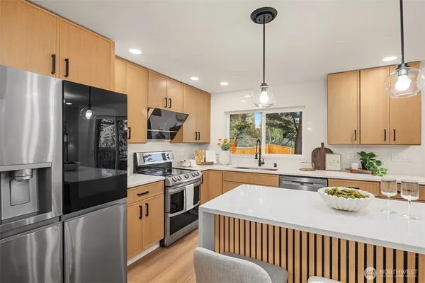 a kitchen with stainless steel appliances granite countertop a sink stove and refrigerator