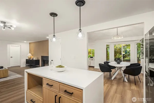 a kitchen with a table chairs stove and wooden floor