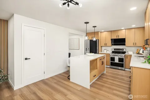 a kitchen with stainless steel appliances a refrigerator and a stove top oven
