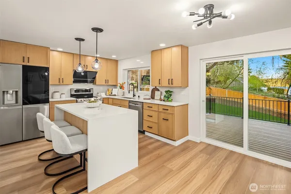 a large kitchen with a table chairs refrigerator and a large window