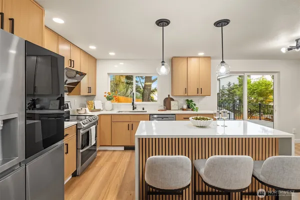 a kitchen with kitchen island granite countertop a sink a counter space appliances and cabinets