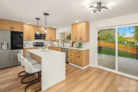 a large kitchen with a table chairs refrigerator and a large window