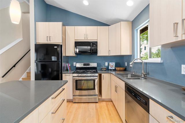 a kitchen with stainless steel appliances a sink a stove a microwave and cabinets