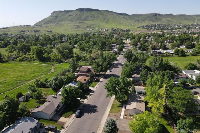 an aerial view of green landscape with trees houses and mountain view