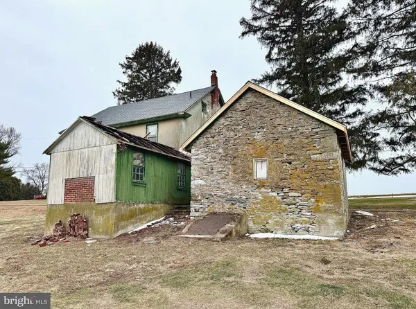 a brick house with a small yard and large trees