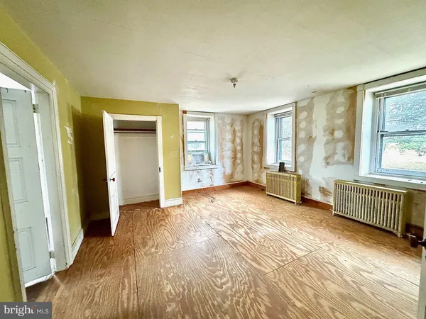 an empty room with windows and closet