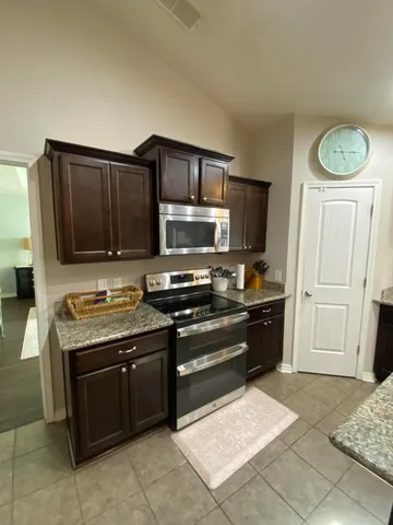 a kitchen with stainless steel appliances granite countertop a stove and a microwave