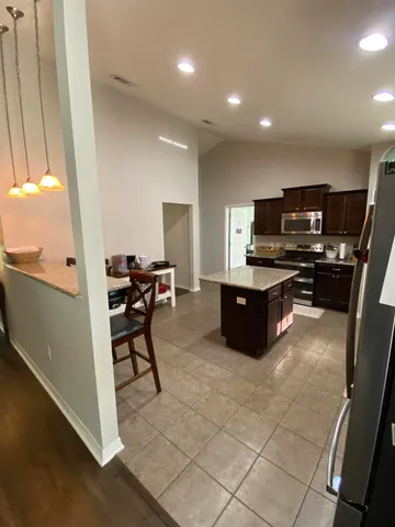 a kitchen with stainless steel appliances a sink a stove a microwave a counter top space and cabinets