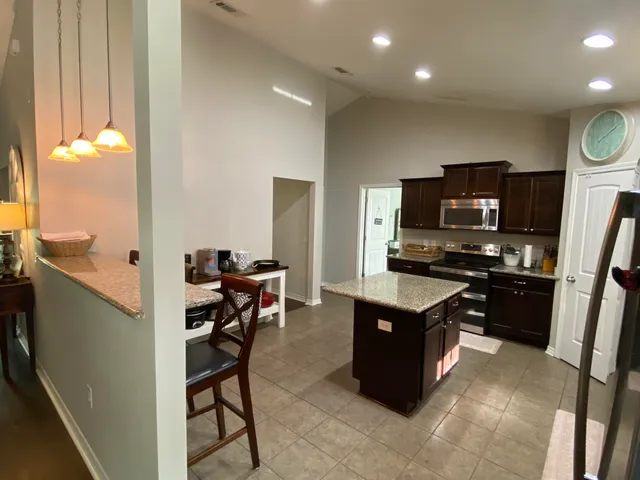 a kitchen that has a lot of cabinets in it and stainless steel appliances