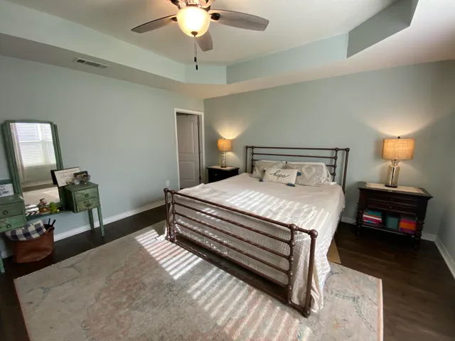 a bedroom with bed and wooden floor