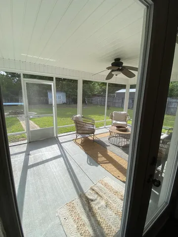 a living room with patio furniture and a floor to ceiling window