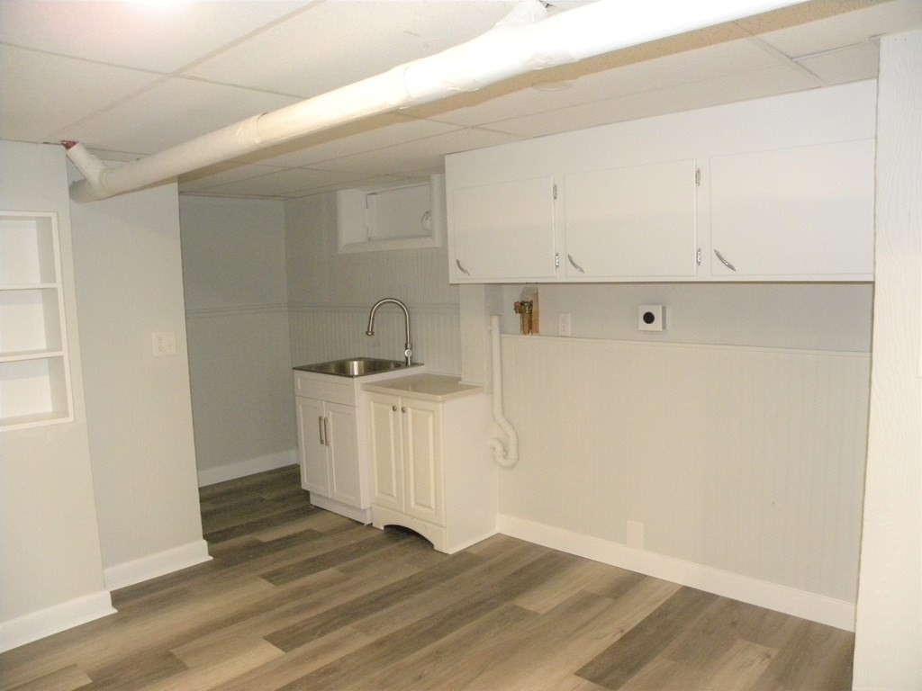 30 Arbor Road Chelmsford, MA 01863 - Photo 28 of 32 a view of a kitchen with white cabinets and wooden floor