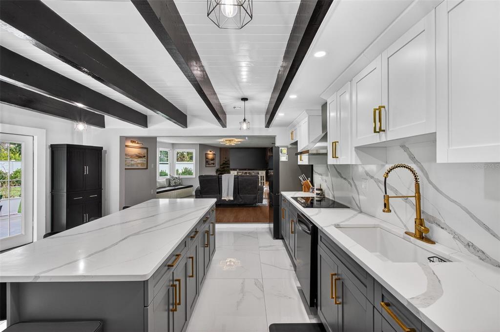 1714 Indian Rocks Road Belleair, FL 33756 - Photo 19 of 62 a kitchen with stainless steel appliances a sink dishwasher a stove a refrigerator a sink a dining table and chairs with wooden floor