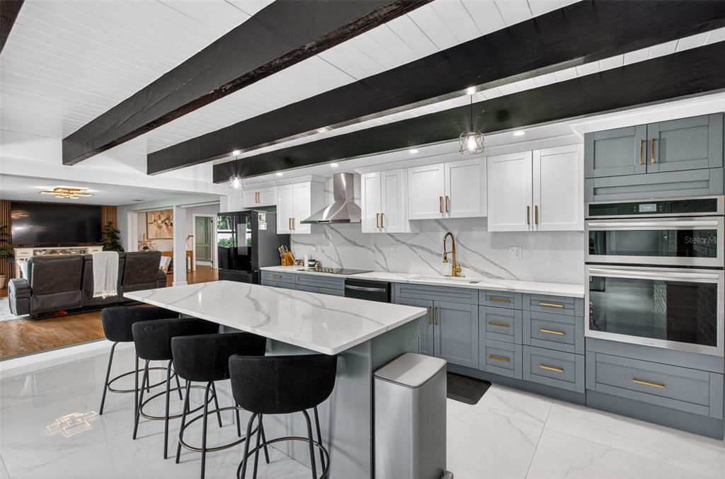 1714 Indian Rocks Road Belleair, FL 33756 - Photo 22 of 62 a kitchen with stainless steel appliances kitchen island granite countertop a table chairs in it and wooden floors