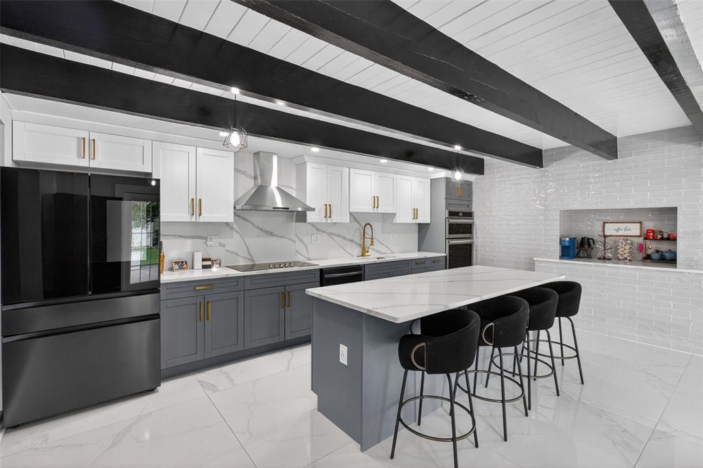 1714 Indian Rocks Road Belleair, FL 33756 - Photo 24 of 62 a kitchen with stainless steel appliances kitchen island a table chairs in it and wooden floors