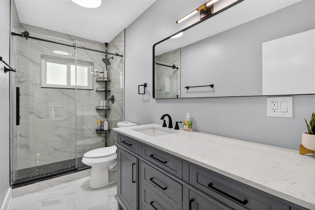1714 Indian Rocks Road Belleair, FL 33756 - Photo 36 of 62 a bathroom with a granite countertop sink a toilet and shower