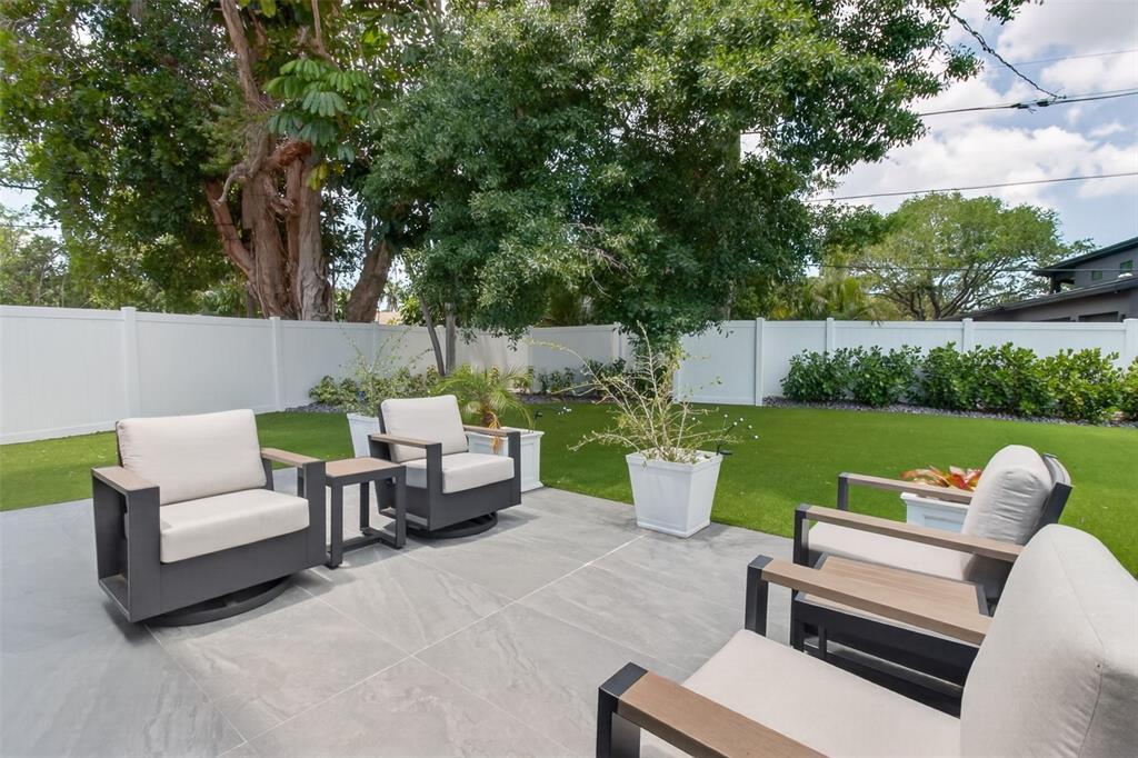 1714 Indian Rocks Road Belleair, FL 33756 - Photo 42 of 62 a view of a patio with couches potted plants and a big yard