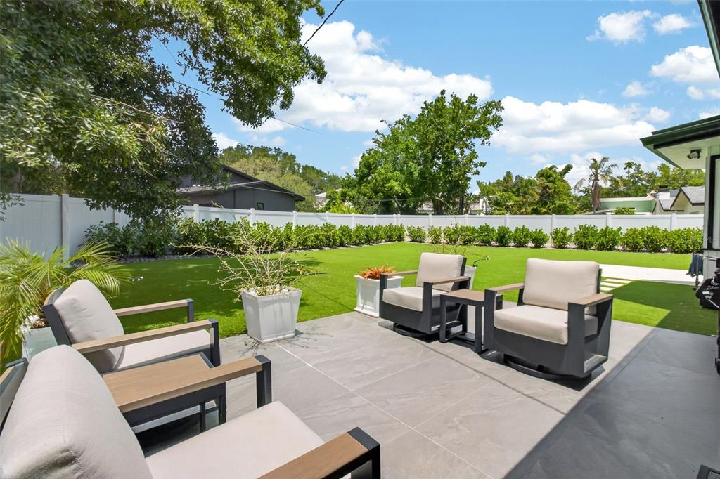 1714 Indian Rocks Road Belleair, FL 33756 - Photo 43 of 62 a view of a patio with couches potted plants and a big yard