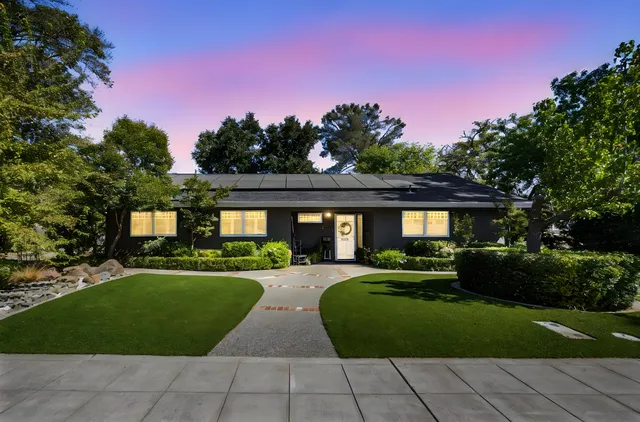 a front view of a house with a yard and trees