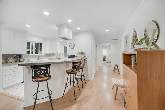 a large kitchen with stainless steel appliances granite countertop a lot of cabinets a stove and a refrigerator