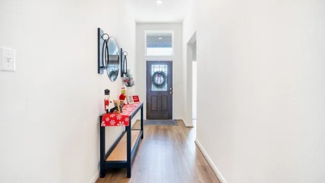 a view of a hallway with wooden floor and a living room