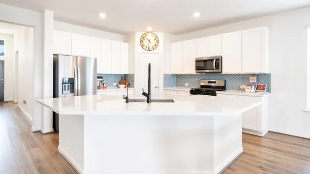 a kitchen with a sink cabinets and wooden floor