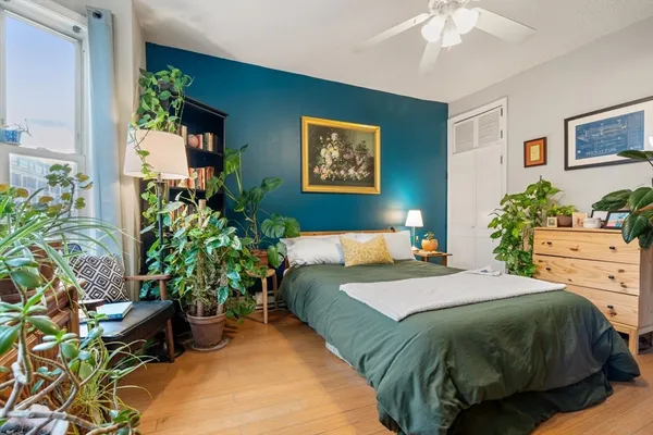 a bedroom with a bed and a potted plant