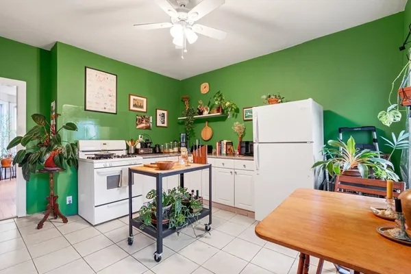 a kitchen with stainless steel appliances a table and chairs in it