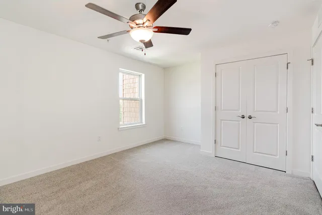 an empty room with fan and windows