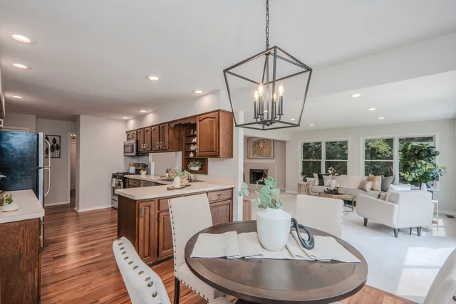 a living room with furniture a dining table and a chandelier
