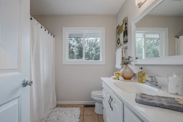 a bathroom with a sink toilet and window