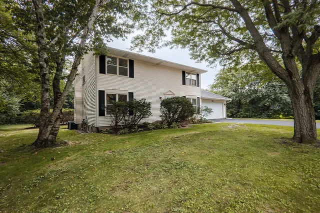 a view of a house with backyard and a tree