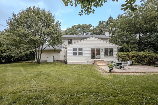 a view of a house with backyard and sitting area