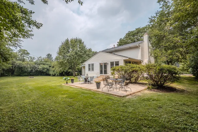 a view of a patio with table and chairs and potted plants with large tree
