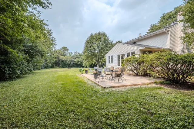 a view of a house with backyard and sitting area