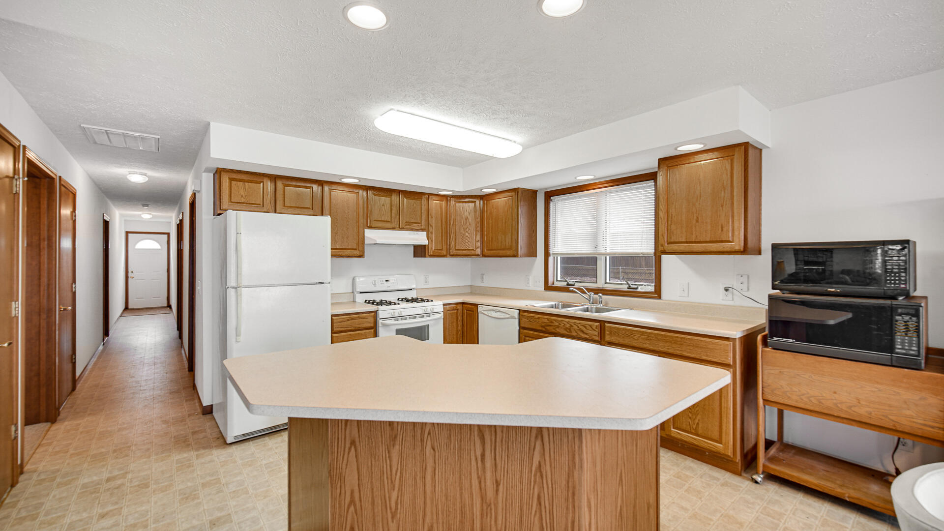 4472 South County Road 210 Knox, IN 46534 - Photo 8 of 30 a kitchen with stainless steel appliances granite countertop a refrigerator a stove and a sink with wooden floor