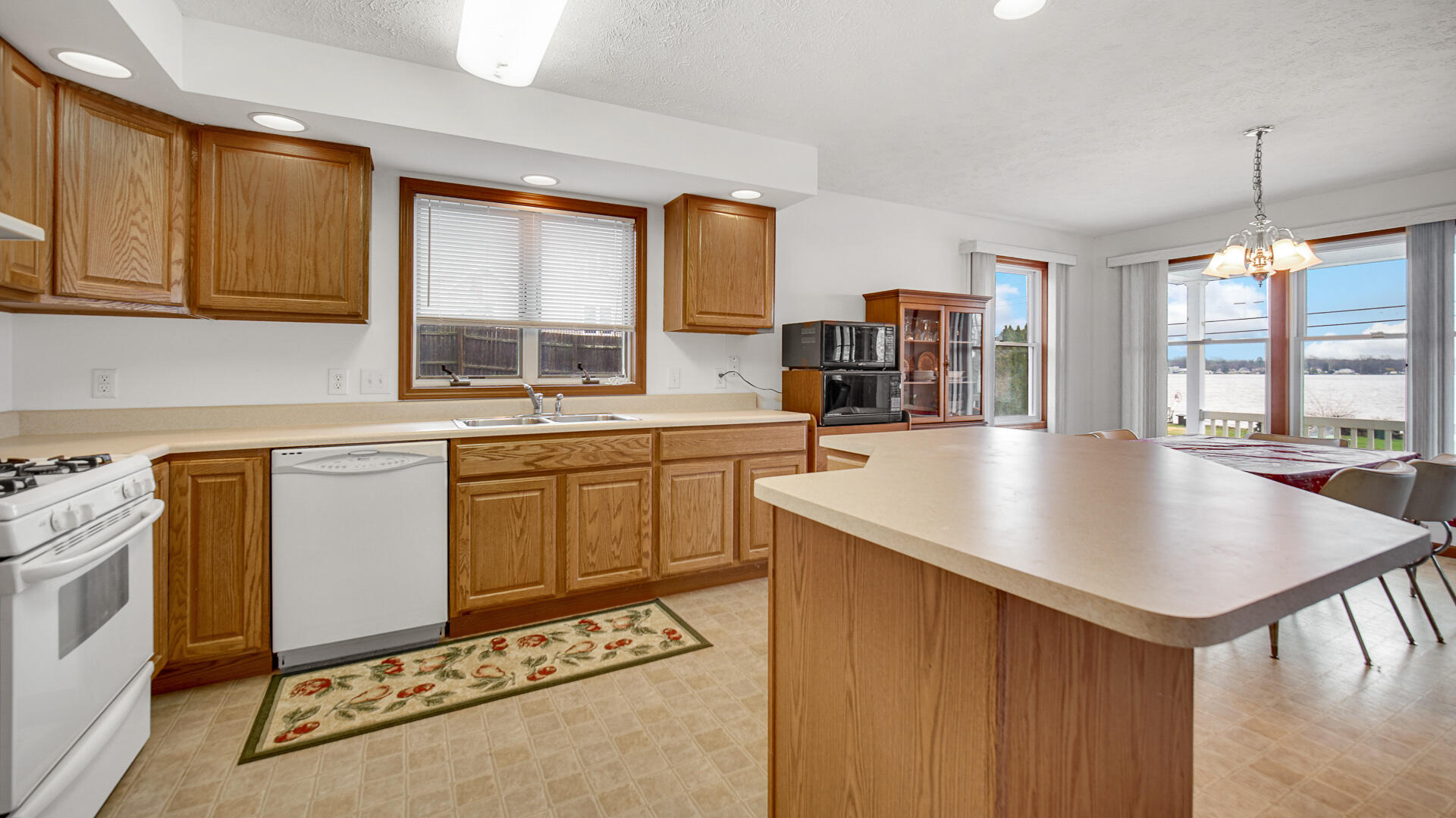 4472 South County Road 210 Knox, IN 46534 - Photo 9 of 30 a kitchen with a sink a stove and cabinets