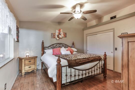 424 Mavis Court Ridgecrest, CA 93555 - Photo 18 of 32 a bedroom with a bed a chandelier and a dresser