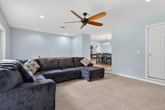 a living room with furniture and a ceiling fan