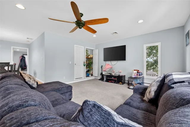 a living room with furniture and a flat screen tv with wooden floor
