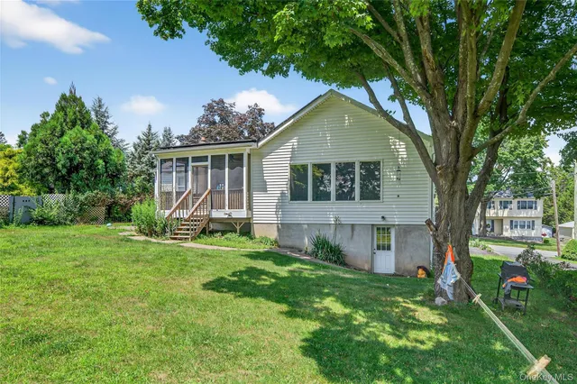 a view of a backyard with potted plants and large tree